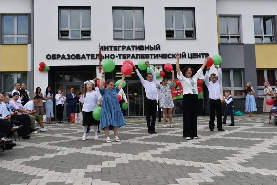 Eine tanzende Gruppe vor dem Schulgebäude